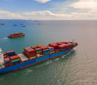 Container ship in export and import business and logistics in the ocean. Water transport International. Aerial view